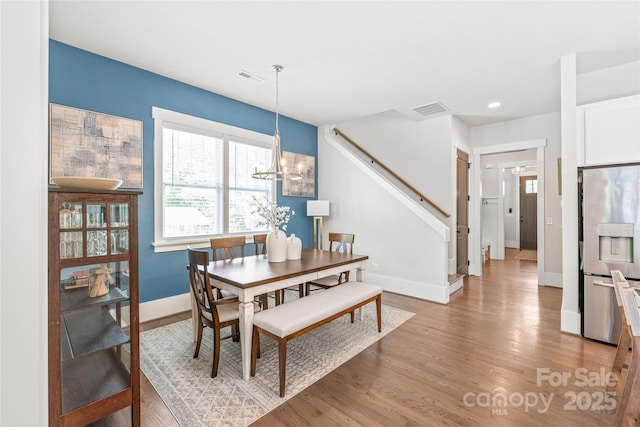 5210 Kelly St, Charlotte, NC 28205 - dining room with light wood-style flooring, a chandelier, baseboards, stairway, and recessed lighting
