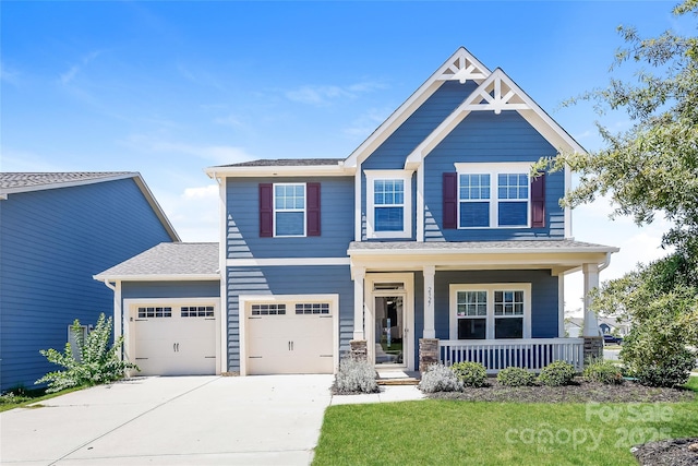 craftsman inspired home with a porch, concrete driveway, roof with shingles, a garage, and a front yard