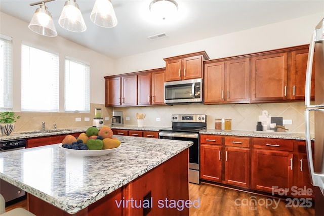 kitchen featuring appliances with stainless steel finishes, a sink, and decorative backsplash