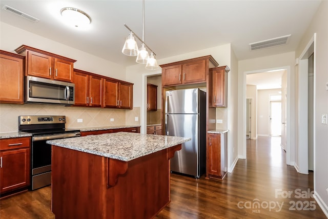 kitchen featuring stainless steel appliances, decorative backsplash, dark wood-style floors, and a center island