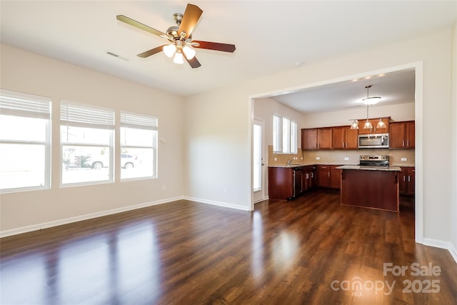 kitchen with stainless steel appliances, dark wood-type flooring, a kitchen island, and open floor plan