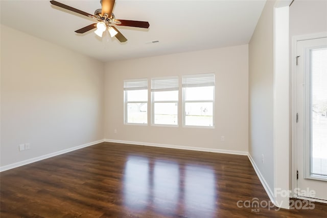 unfurnished room featuring healthy amount of natural light, wood finished floors, a ceiling fan, and baseboards