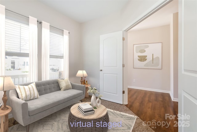 living area featuring baseboards and wood finished floors