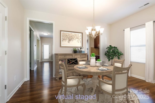 dining space featuring dark wood finished floors, a chandelier, and baseboards