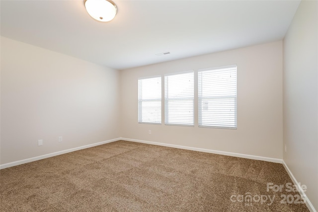 carpeted spare room with baseboards