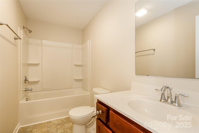 bathroom featuring toilet, vanity, stone finish flooring, and bathtub / shower combination