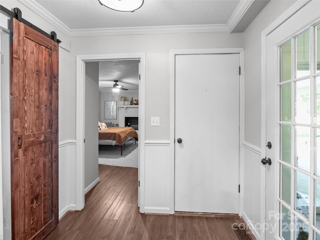 1544 US-221A Hwy, Mooresboro, NC 28114 - entrance foyer with wood finished floors, a textured ceiling, a barn door, ornamental molding, and ceiling fan