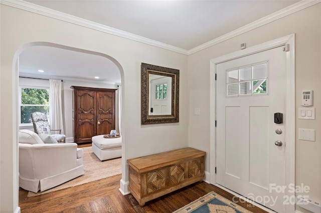 foyer featuring arched walkways, wood finished floors, baseboards, ornamental molding, and recessed lighting