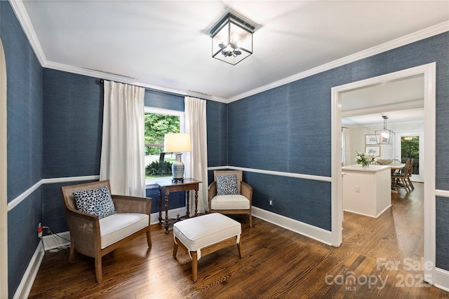 living area featuring wood finished floors, plenty of natural light, crown molding, a chandelier, and wallpapered walls