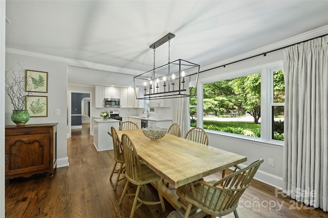 dining room with healthy amount of natural light, ornamental molding, dark wood-type flooring, baseboards, and a chandelier