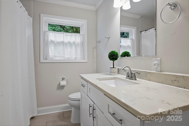 bathroom with crown molding, vanity, baseboards, and toilet