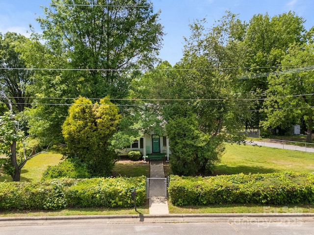 view of property hidden behind natural elements featuring a gate