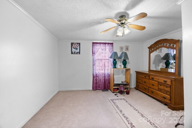 carpeted bedroom featuring crown molding, a textured ceiling, ceiling fan, and baseboards