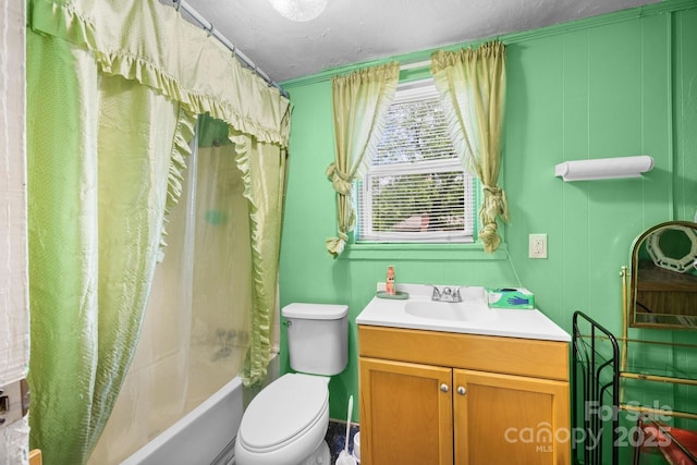 bathroom featuring toilet, vanity, shower / bath combo with shower curtain, and a textured ceiling