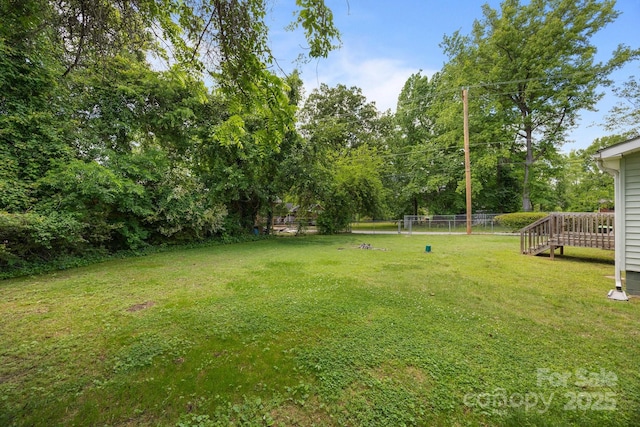 view of yard featuring a wooden deck and view of scattered trees