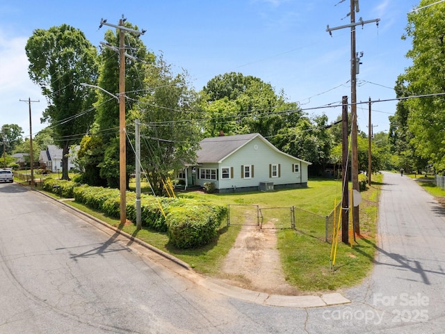 view of front of home with a gate, central AC unit, and driveway
