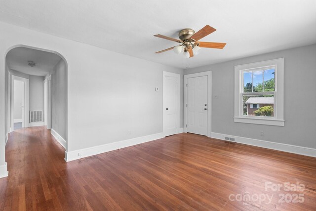 2336 32nd St NE, Hickory, NC 28601 - empty room with wood finished floors, baseboards, ceiling fan, and arched walkways