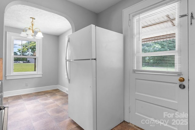 2336 32nd St NE, Hickory, NC 28601 - kitchen with freestanding refrigerator, a chandelier, baseboards, pendant lighting, and arched walkways