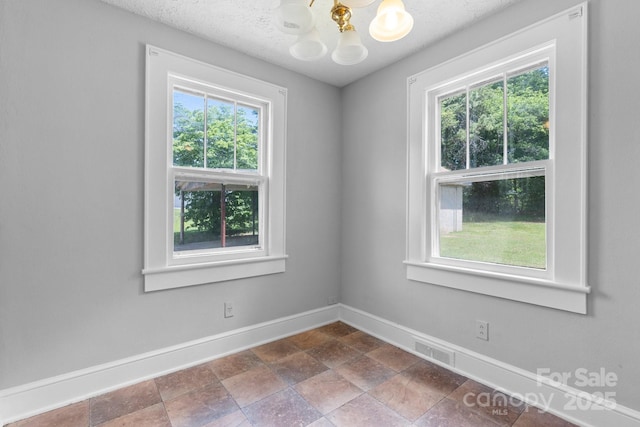 2336 32nd St NE, Hickory, NC 28601 - empty room with baseboards, a chandelier, and dark stone finish floors