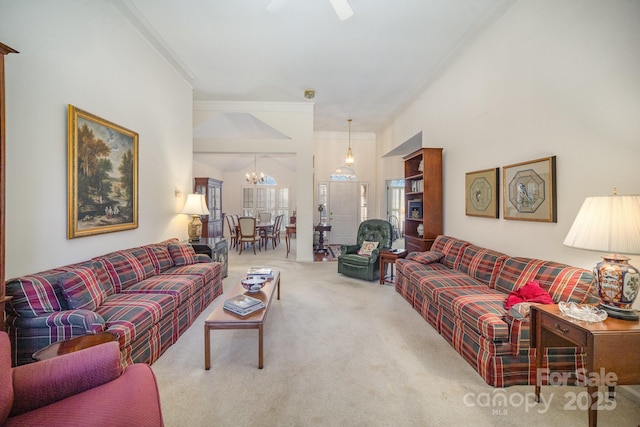 carpeted living room featuring a chandelier, a ceiling fan, and ornamental molding