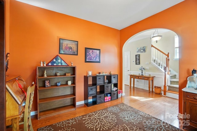 541 River Park Rd, Belmont, NC 28012 - living area with arched walkways, wood finished floors, stairs, and a wainscoted wall
