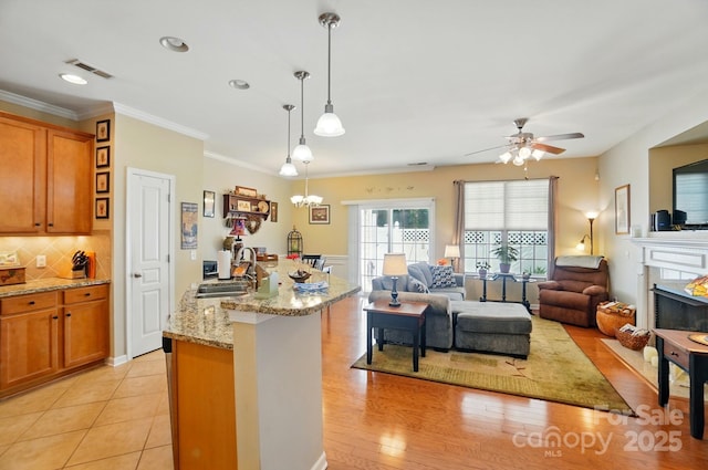 541 River Park Rd, Belmont, NC 28012 - kitchen featuring brown cabinetry, a sink, open floor plan, backsplash, and ornamental molding
