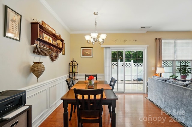 541 River Park Rd, Belmont, NC 28012 - dining area with a chandelier, wood finished floors, ornamental molding, wainscoting, and a decorative wall