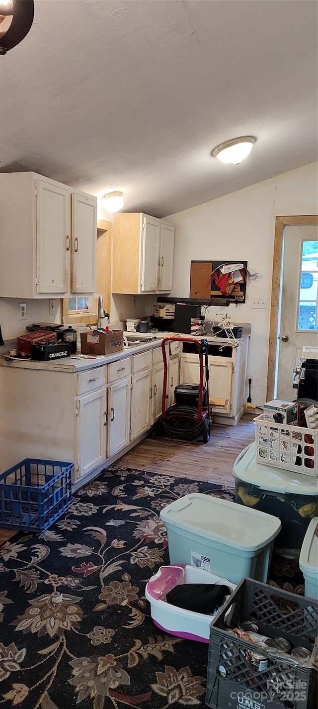 7881 Us-25/70 Hwy, Marshall, NC 28753 - kitchen with white cabinets, lofted ceiling, wood finished floors, and a sink