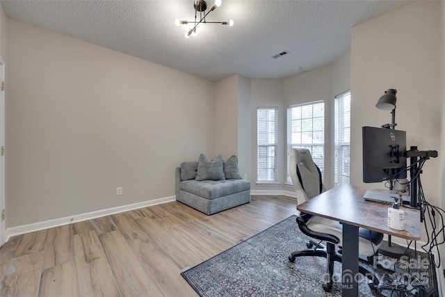 office area with wood finished floors, a textured ceiling, a chandelier, and baseboards