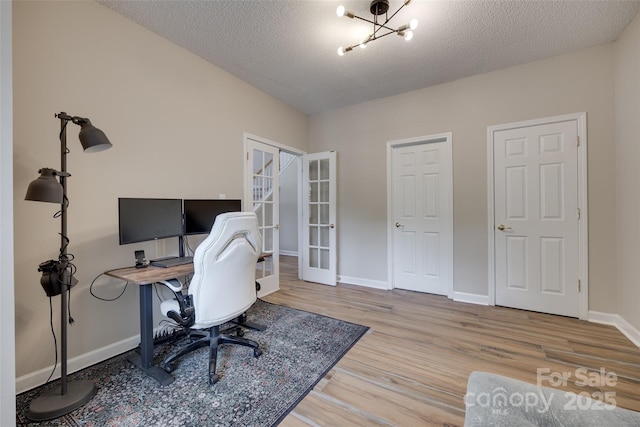 office area with wood finished floors, french doors, a textured ceiling, baseboards, and a chandelier