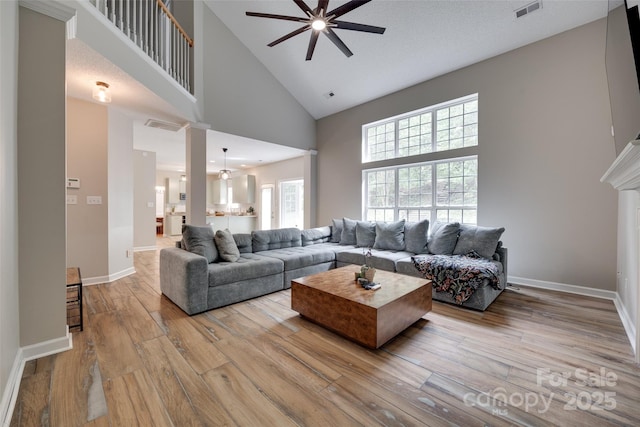 living room featuring high vaulted ceiling, ceiling fan, wood-type flooring, and baseboards