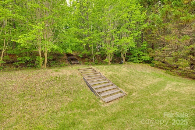 view of grassy yard featuring stairway