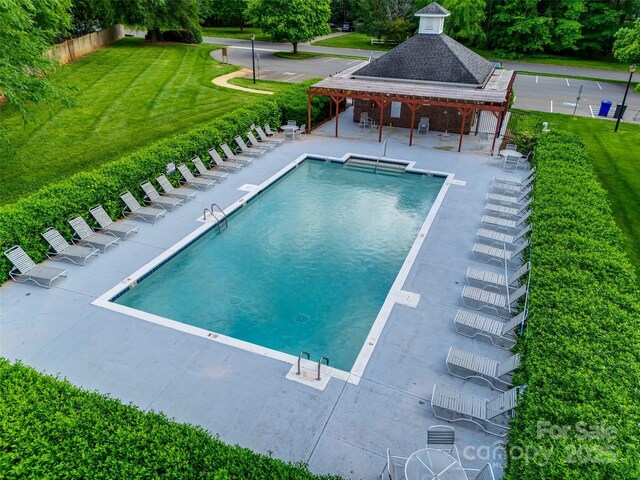 community pool featuring a lawn and a patio area