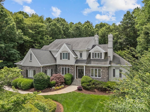 9831 Sedgefield Dr, Waxhaw, NC 28173 - view of front of house with stone siding, stucco siding, a front lawn, and a chimney