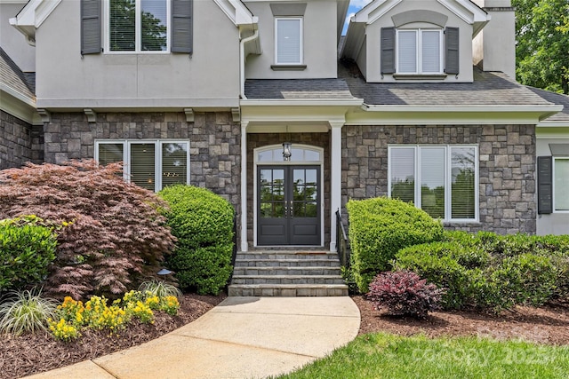 9831 Sedgefield Dr, Waxhaw, NC 28173 - view of exterior entry featuring stone siding, french doors, stucco siding, and a chimney