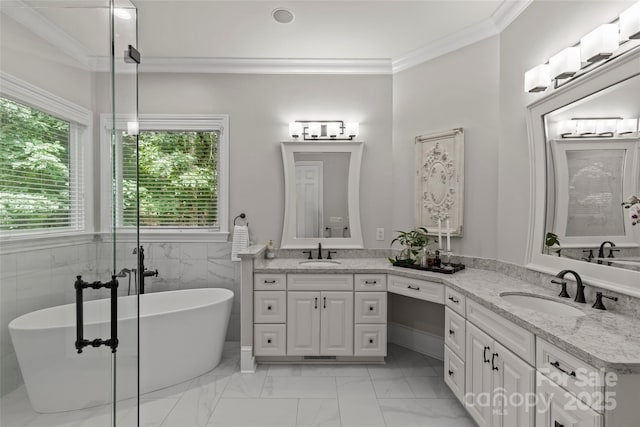9831 Sedgefield Dr, Waxhaw, NC 28173 - full bathroom featuring marble look tile flooring, a freestanding bath, double vanity, ornamental molding, and a wainscoted wall