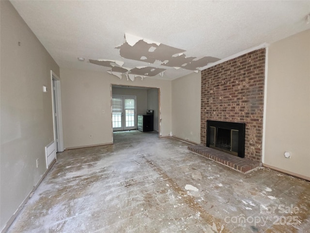 unfurnished living room featuring a brick fireplace and a textured ceiling