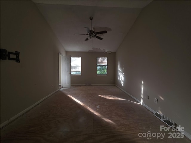 unfurnished room featuring lofted ceiling, a ceiling fan, and baseboards