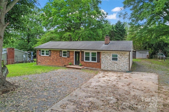 2401 Woodleaf Dr, Gastonia, NC 28052 - ranch-style house with a chimney, a storage shed, an outdoor structure, and brick siding