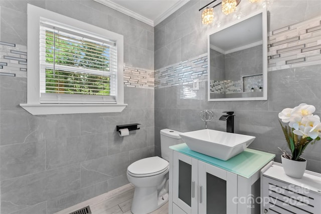 2401 Woodleaf Dr, Gastonia, NC 28052 - bathroom featuring ornamental molding, vanity, tile walls, toilet, and wood finished floors
