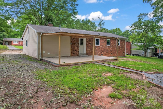 2401 Woodleaf Dr, Gastonia, NC 28052 - back of property featuring a patio area, a chimney, a yard, and brick siding