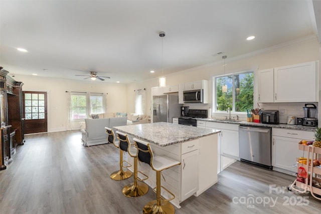 131 Swink St SW, Concord, NC 28027 - kitchen with appliances with stainless steel finishes, a kitchen island, a sink, healthy amount of natural light, and recessed lighting