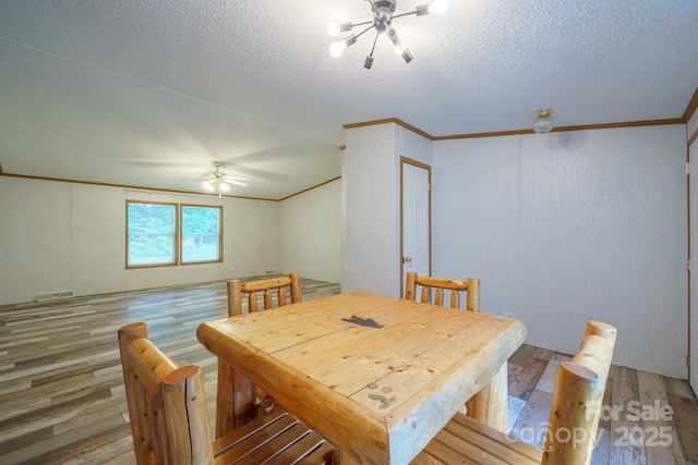 3823 Silver Creek Ter, Morganton, NC 28655 - dining space featuring light wood-type flooring, ornamental molding, a textured ceiling, a ceiling fan, and a chandelier