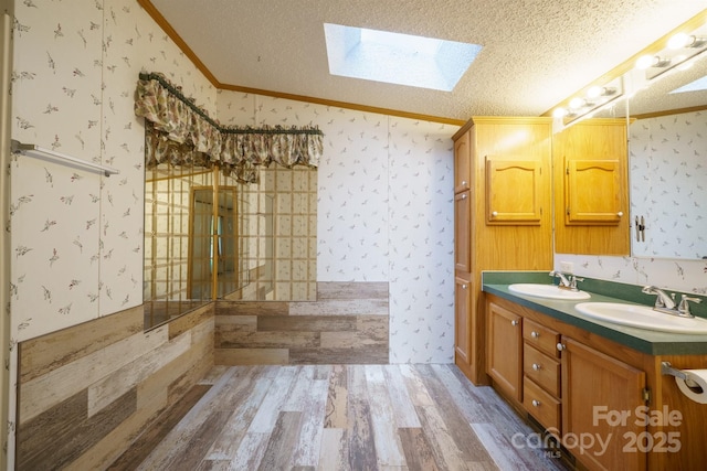 3823 Silver Creek Ter, Morganton, NC 28655 - full bathroom featuring crown molding, wallpapered walls, wood finished floors, a skylight, and double vanity