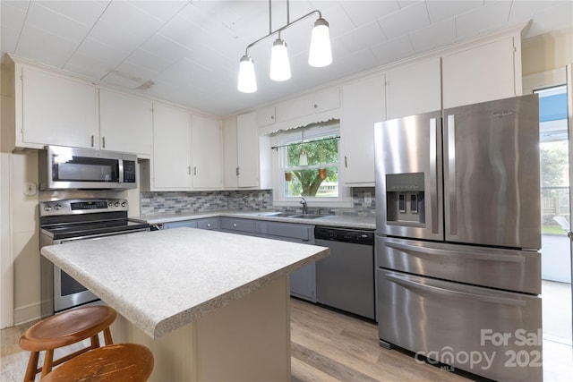80 Pine St, Badin, NC 28009 - kitchen featuring stainless steel appliances, a sink, tasteful backsplash, light wood-style flooring, and a kitchen bar