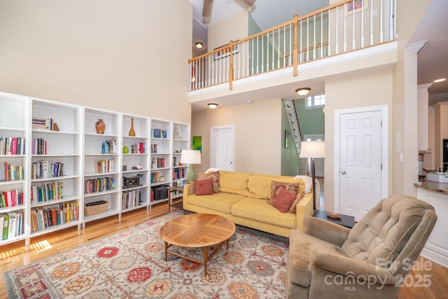 living room with a high ceiling and wood finished floors