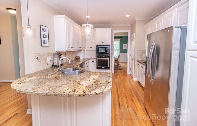 kitchen with black appliances, a sink, a peninsula, light wood-style flooring, and white cabinets