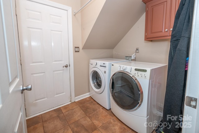 clothes washing area with washing machine and dryer, cabinet space, and baseboards