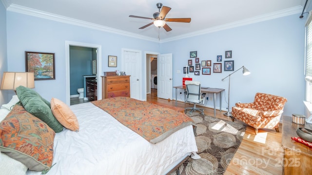 bedroom with crown molding, washer / clothes dryer, wood finished floors, baseboards, and connected bathroom