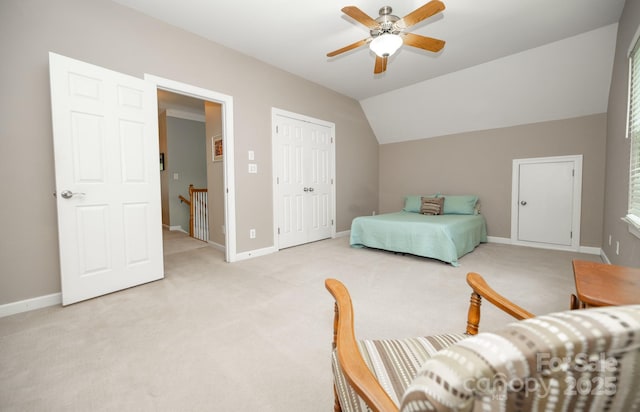 bedroom with light colored carpet, baseboards, lofted ceiling, a closet, and a ceiling fan
